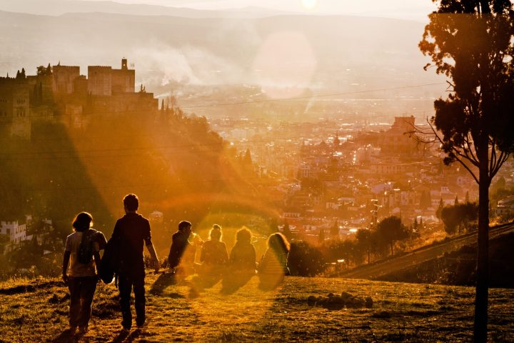 a group of people standing in front of a sunset